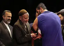 پهلوان ایران بازوبند خود را به حرم امام رضا (ع) تقدیم می‌کند